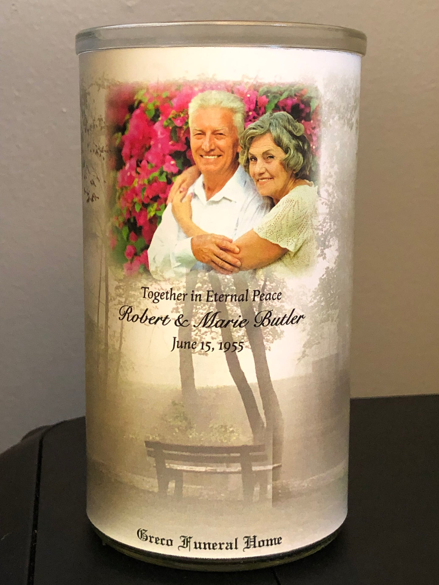 Memorial candle with an image of an elderly couple and text on a white background